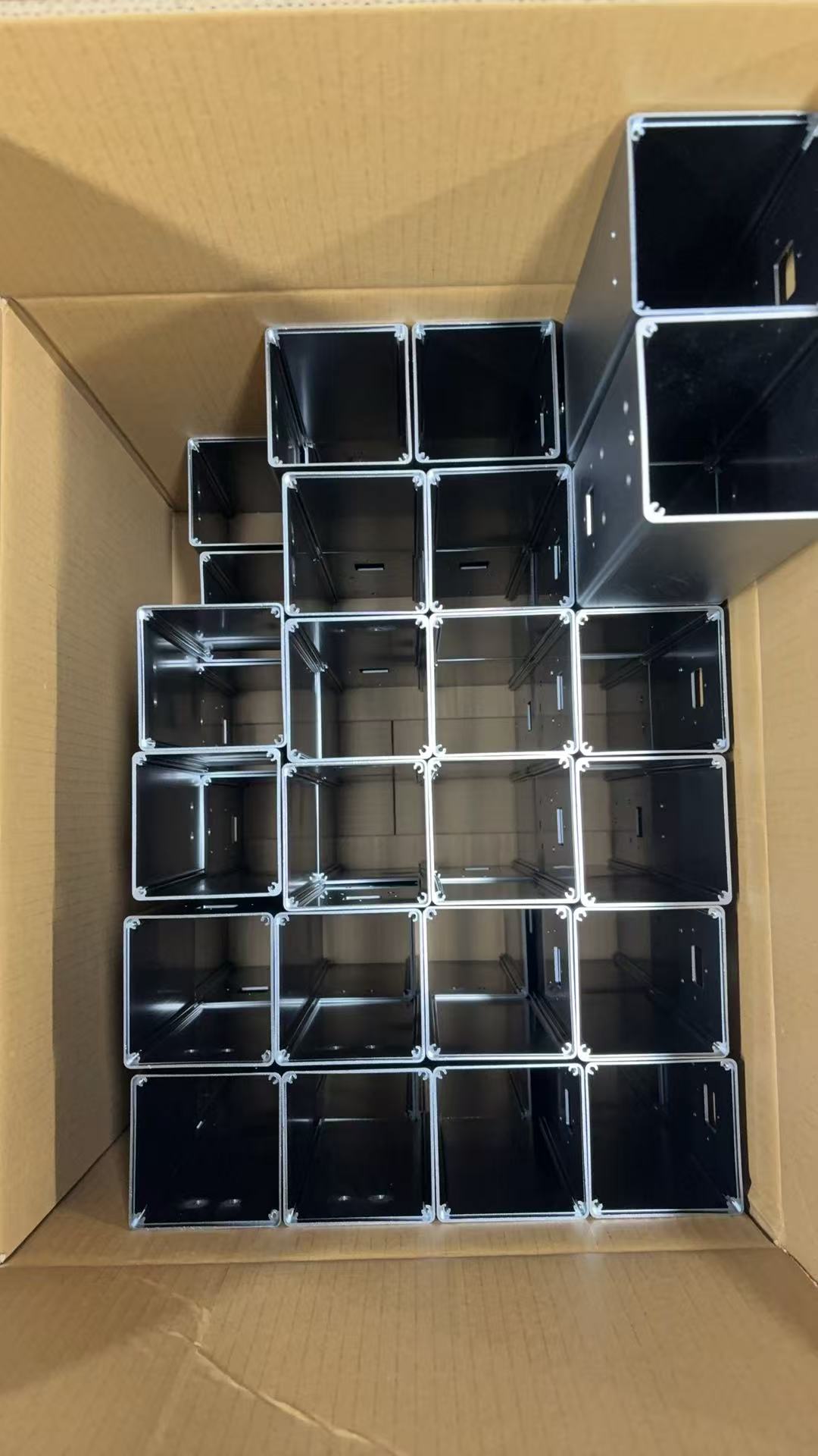 Top view of AntBelt G1 metal enclosure components organized in a production carton